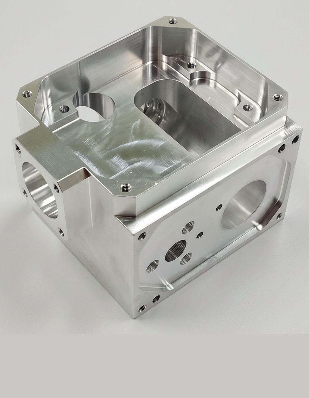Machined aluminium aerospace housing with pocketed faces and threaded bosses